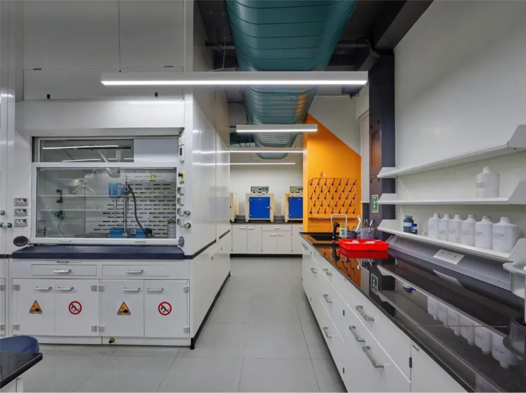 Modular lab furniture setup with chemical resistant laboratory workbench, storage cabinets and sink unit manufactured by Ambalica in India.